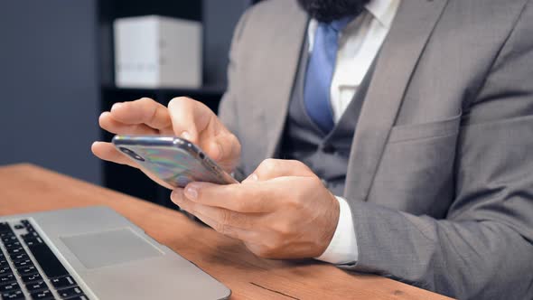 Close Up Middle Aged Businessman Using Smartphone in Office
