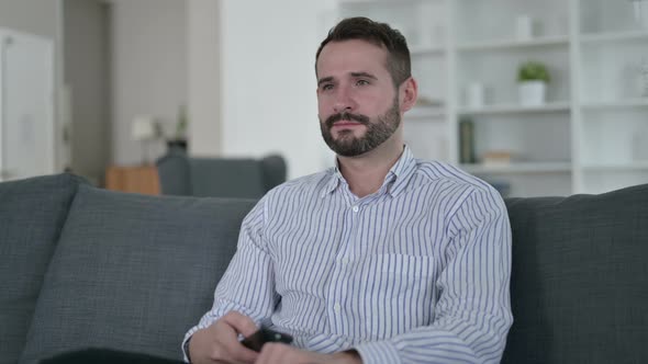 Attractive Young Man Watching Television at Home 