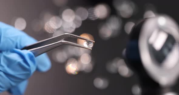 Gloved Jeweler Holds Pair of Tweezers with Transparent Gemstone  Movie