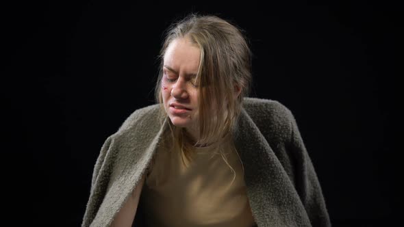 Alcoholic Woman With Wounded Face Drinking Beer, Looking in Mirror and Crying