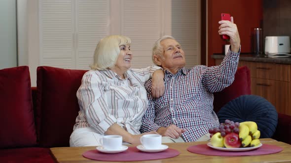 Senior Family Having Fun, Making Selfie Photos, Recording Video Together on Smartphone at Home