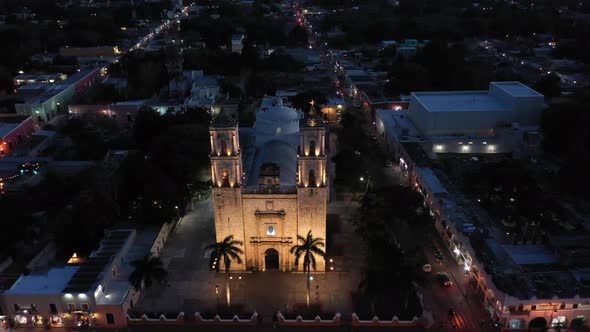 Slow nighttime aerial pull back from the Catedral de San Gervasio in Valladolid, Yucatan, Mexico.