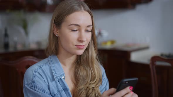 Young Absorbed Millennial Woman Texting on Smartphone As Loving Man Hugging and Kissing Partner