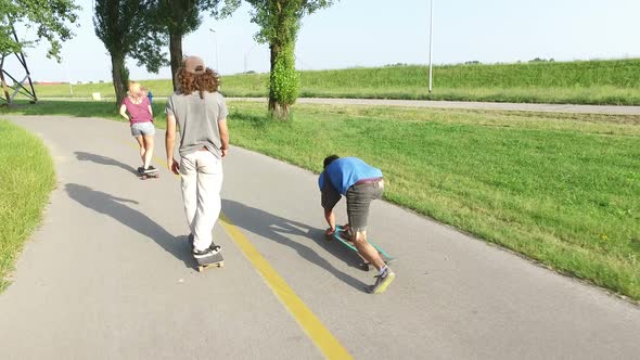 Three young people skateboarding together