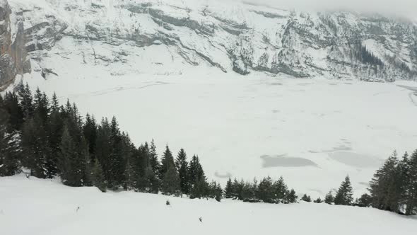 Aerial reveal of beautiful frozen lake surrounded by mountains