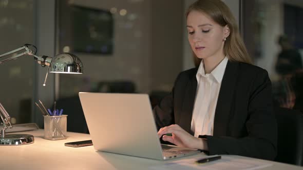 Young Businesswoman Working on Laptop on Office Table at Night 