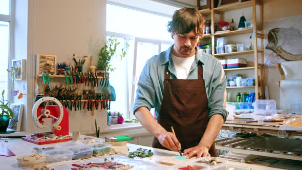 Young man cutting a piece of glass