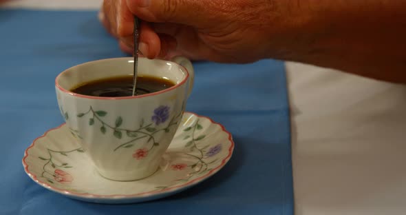 Close-up of hand stirring tea