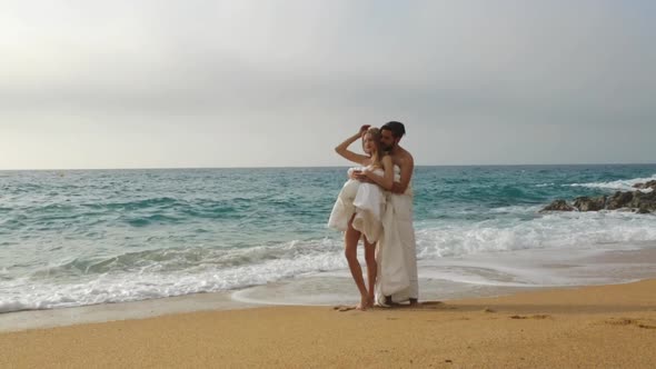 Young beautiful couple on beach in blankets