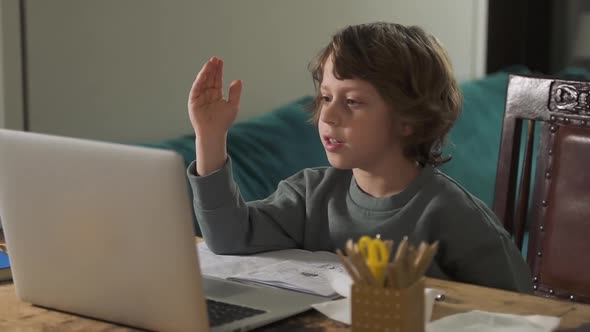 Cute Schoolboy Is Studying Online at Table with Laptop in Apartment During Quarantine Spbd