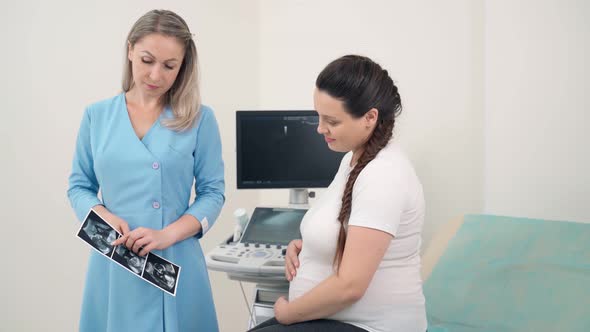 Doctor Showing Ultrasound Pictures for Pregnant Woman