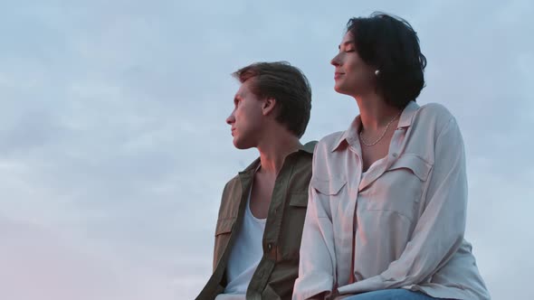 Young Woman and Her Boyfriend Sitting on Pier