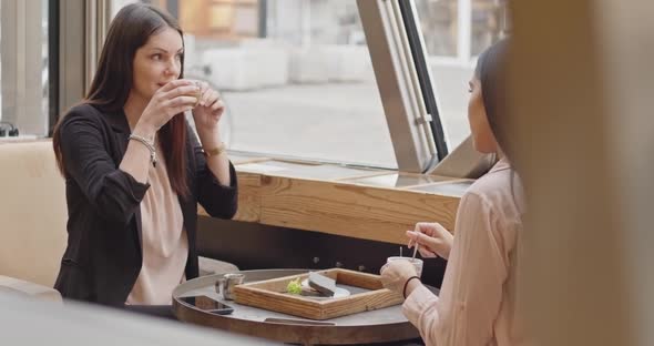 Back View of Two Adult Business Women Sitting and Talking in a Bar