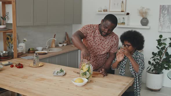 African American Father and Son Making Homemade Lemonade