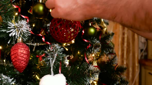 Mans hand put red ball on christmas tree