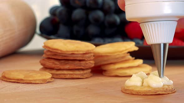 A Woman Makes a Dessert Out of Phyllo Pastry Rounds and Cream, a Plate of Fruits