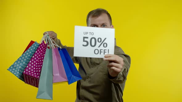 Man Showing Up To 50 Percent Off Inscription and Shopping Bags, Rejoicing Discounts. Black Friday