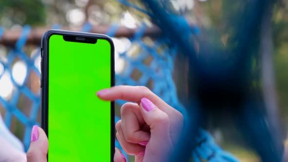 Girl Uses a Smartphone with a Chromakey Screen