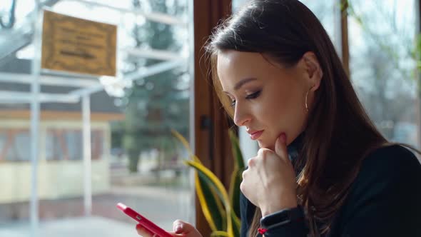 Lady relaxing in cafe. Woman in cafe using mobile phone and texting