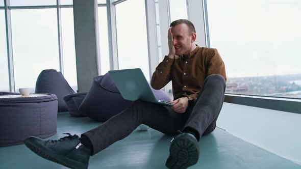 young man sitting on a floor with laptop computer. Work stress concept of man