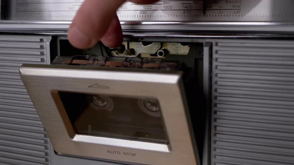 Open Cassette Deck of Old Tape Recorder Pull Out 90s Cassette with Fingers