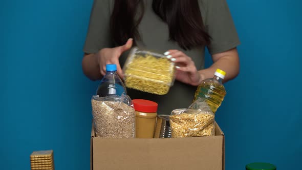 Volunteer Putting Food in a Donation Box. Charity Concept