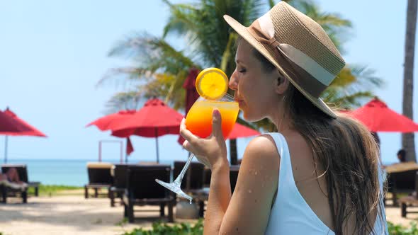 Young Beautiful Woman in Swimming Pool Drinking Refreshing Summer Cocktail on Sunny Day