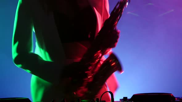 Young Sexy, Blonde Woman Dj in White Jacket and Black Top Playing Music Using Saxophone, Dancing