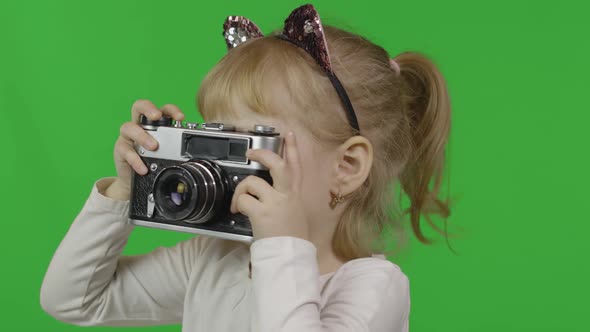 Girl in Cat Headband Taking Pictures on an Old Retro Photo Camera. Chroma Key