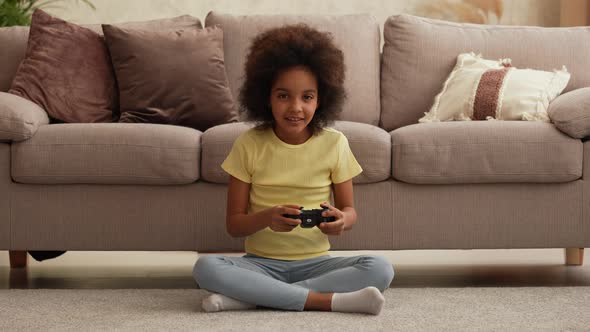 Portrait Little African American Girl Playing a Video Game Using a Wireless Controller