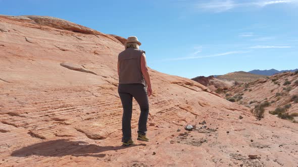 Woman Walking In Desert With Red Rock Canyon