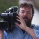 Bearded television cameraman filming outdoors. - VideoHive Item for Sale