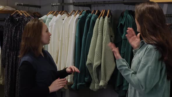 Sales Assistant Helping a Woman to Choose Clothes