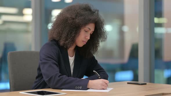 Hardworking African Businesswoman and Writing on Paper