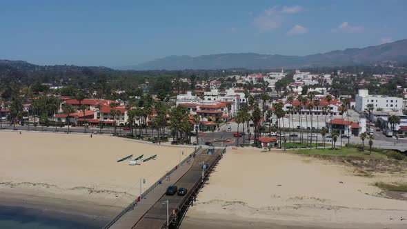 aerial drone of cars crossing the Stearns Wharf Pier in downtown Santa Barbara on a sunny summer day