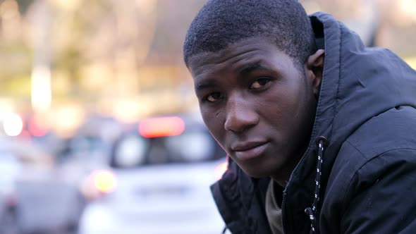 Confident attractive young black african man looking at camera in the street