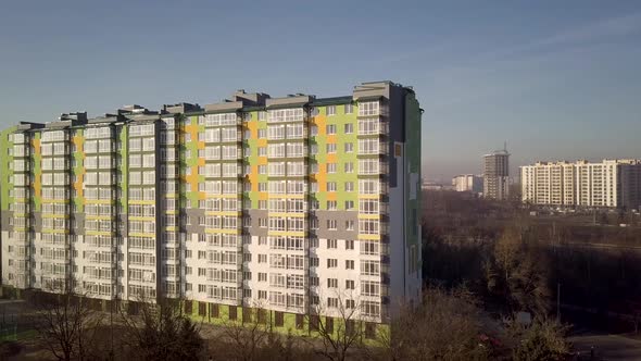 Aerial footage of a tall residential apartment building with many windows and balconies.