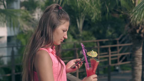 Woman with Berry Cocktail in Hand Stands on Hotel Territory