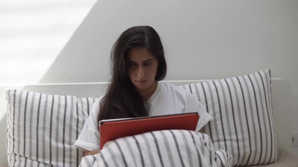 Front Shot of a Woman in Bed with Tablet.