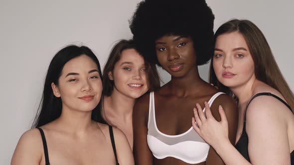 Four beautiful women standing toghether, smiling and hugging