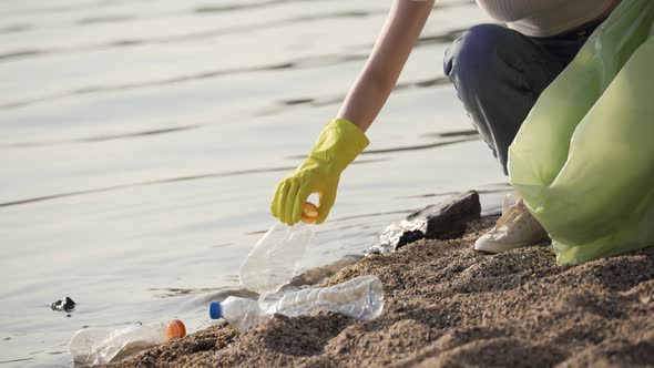 A Woman Cleans Up Trash at the Lake