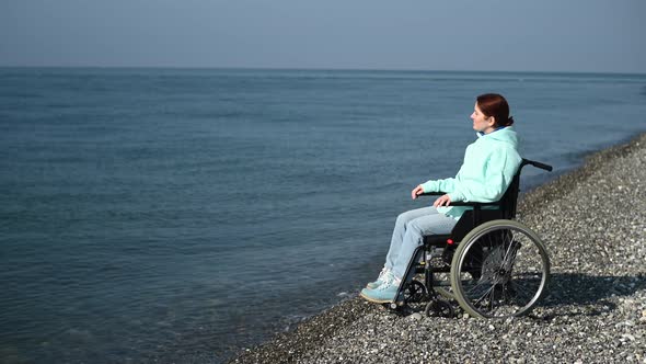 Pacified Caucasian Woman in a Wheelchair on the Seashore