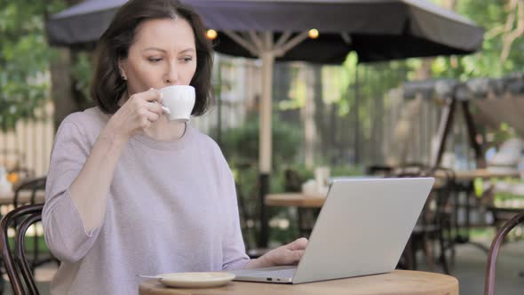 Outdoor, Old Woman Drinking Coffee and Working on Laptop