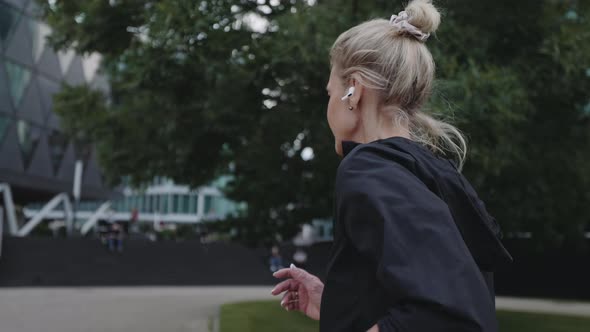 Senior Woman in Earphones Spending Free Time for Urban Run