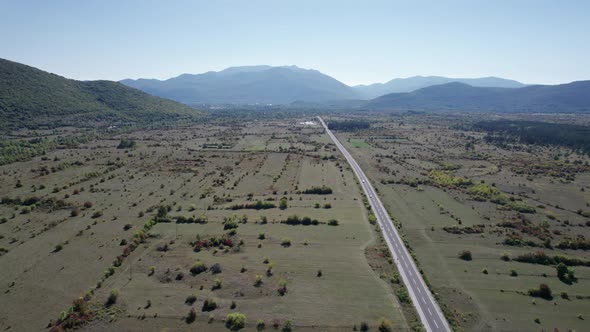 Empty Asphalt Road on the Plateau Between Green Fields Highland Way Aerial View