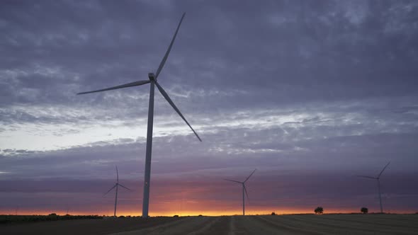 Sunset with Modern Wind Turbines Silhouette and Cloudscape