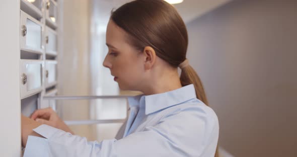 Young Woman Checking Mailbox and Feeling Irritated Receiving Bad News