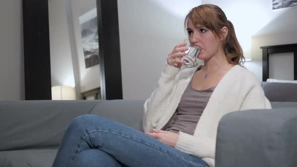 Relaxing Woman Drinking Water While Sitting on Couch