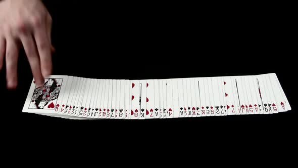 Playing Cards Being Spread on a Black Surface By Magician