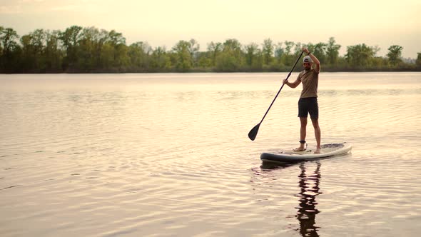 Man Sup Surfing .Stand up Paddling Surfboard. Inflatable Board For Rowing. Surfer Balance Watersport